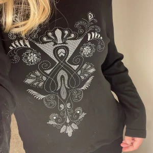 Svart mönstrad långärmad  - Säljer den svincoola svarta långärmade med coolt mönster, då det inte är riktigt min stil:/ Köpt second hand, men väldigt fint skick. Den är från casual woman by Ellos. Strl 46/48, men jag brukar ha S/M, så det bros på hur du vill att den ska sitta!<3 