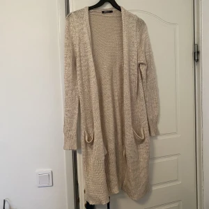 Stickad kofta från Gina Tricot  - Fin stickad koft från Gina Tricot. Mysig och i en fin beige färg. Perfekt till hösten och vintern!!