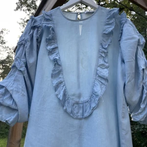 Zara blus  - Säljer denna jeans blus från zara woman med volanger. Den har en liten fläck se sista bild