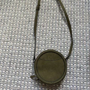 Rund axelväska - Axelväska, aldrig använd. Justerbart axelband. 