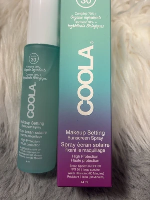 COOLA Makeup Setting Face Mist SPF 30 - Fräsch makeup setting face mist från COOLA med SPF 30. Innehåller över 70% ekologiska ingredienser. Kommer i en stilren, frostad turkos flaska med vit kork och rymmer 44 ml. Ger hög skyddsnivå och är vattenresistent i 80 minuter.