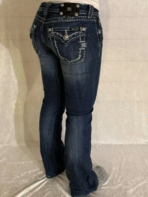 Miss Me Jeans - Säljer dessa jättefina Miss Me bootcut Jeans! Storlek: W28. Modellen är 167cm och väger 60kg. På ena bakfickan så har knappen lossnat och därför är priset 500. Annars är dem i mycket bra skick utan skador.