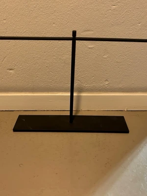 Svart metallställ för accessoarer - Snyggt och stilrent svart ställ i metall, perfekt för att hänga smycken, solglasögon eller andra accessoarer. Rektangulär bas och enkel design som passar in i de flesta rum. Perfekt för att organisera dina favoritsaker på ett trendigt sätt.   Finns 2 kvar 55kr/st , som ny 