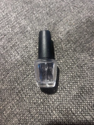 OPI Top Coat genomskinligt nagellack - OPI Top Coat är ett genomskinligt nagellack som ger en snygg glansig finish och skyddar din manikyr. Kommer i en klassisk OPI-flaska med svart kork och är perfekt för att försegla färgat nagellack eller användas ensamt för naturlig look.