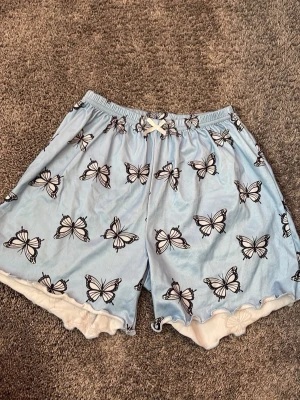 Fina pyjamas shorts - Köparen står för frakt. Säljer ett par söta ljusblå pyjamasshorts från Stein i storlek 11–12 år. De har fina fjärilar och lite gulliga volanger som gör dem extra söta! 🦋💕✨  ✨ Märke: Stein ✨ Färg: Ljusblå ✨ Storlek: 11–12 år ✨ Motiv: Fjärilar 🦋 ✨ Detaljer: Söta volanger ✨ Skick: Fint använt skick.  Hör gärna av dig om du har frågor eller vill ha fler bilder! 💕