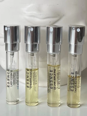 ESSNCE parfym - Fyra små parfymsprayer från ESSNCE i genomskinliga glasflaskor med silverfärgade spraylock. Doftnamnen är LADYESSENCE, CHERRYLICIOUS, DRUNK APPLE PIE och TARTE AU CITRON. Perfekta att ha med i väskan för en fräsch doft när som helst. Se bild för mängd kvar. Kostar 130kr/st på hemsidan. 