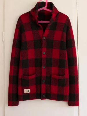 🟥 Vintage Polo Ralph Lauren rutig stickad kofta 🖤 - Superfin och unik stickad kofta/cardigan från Polo Ralph Lauren i klassiskt röd- och svartrutigt buffalo check-mönster. Modellen har hög sjalkrage, knappstängning framtill och två fickor. Storlek: M (10–12 år) Färg: Röd/svart Skick: Fint begagnat skick utan defekter! Riktigt snygg modell som passar perfekt till höst/vinter – ger en klassisk preppy/vintage Ralph Lauren-look 🍂 Skriv gärna vid frågor eller om du vill ha mått!
