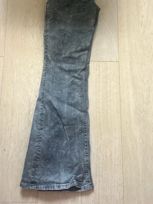 Grå bootcut jeans - Ett par grå jeans med bootcut passform från Gina tricot. Jeansen har klassiska bakfickor och raka ben som blir vidare nedtill. Färgen är en snygg grå nyans. 
