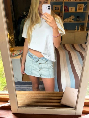 Ljusblå jeanskjol med knappar - Trendig ljusblå jeanskjol i kort modell med knappar framtill. Jag har klippt av kjolen nertill och brukar vika ner kanten upptill så den blir mer low waist!😍