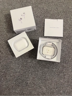 Apple AirPods Pro med laddningsetui - Säljer ett par Apple AirPods Pro i vitt med tillhörande laddningsetui och laddningskabel. Hörlurarna har en stilren och kompakt design i plast och levereras i originalförpackning med manual. Perfekta för trådlös musik och samtal.