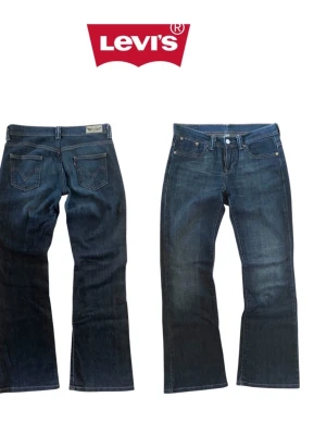 Mörkblå bootcut jeans från Levi's - Snygga mörkblå bootcut jeans från Levi's med klassiska fem fickor och kontrastsömmar. Jeansen har en rak passform upptill och lätt utsvängda ben. Tillverkade i slitstark denim med Levi's ikoniska bakfickor och logga.