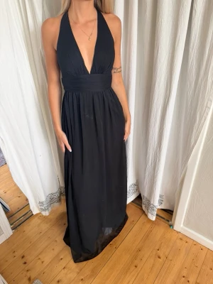 Svart Balklänning🖤 - En super snygg och classy balklänning. Använd 1 gång, finns en liten fläck som jag ej försökt få bort, syns ej pga volangerna och liten fläck. Förövrigt väldigt fint skick med dragkedja på sidan.🖤
