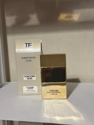 Tom Ford Noir Extreme Parfum 100ml - Tom Ford Noir Extreme Parfum i en lyxig, guldig rektangulär flaska med räfflat lock. Förpackningen är elegant med diskreta ränder och svart text. Doften är intensiv och exklusiv, perfekt för dig som gillar kraftfulla parfymer. Innehåller 100 ml spray.