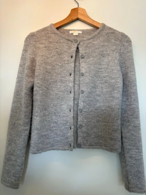 Ljusgrå stickad kofta  - Mysig ljusgrå stickad kofta från Gina tricot i storlek 146/152.