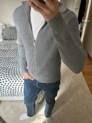 Grå stickad ziptröja med krage från Massimo Dutti - Säljer en stilren grå stickad tröja med dragkedja och krage från Massimo Dutti. Tröjan är i fint skick och är i storleken M men sitter som S! 😁✌🏼———————————————————————————                                                                          📐| Storlek: Medium men sitter som S                                                           👖| Märke: Massimo Dutti                                     🔎| Skick: Bra skick                                                ✍🏻| Skriv om du har några frågor