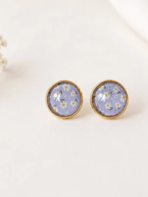 Blommiga örhängen  - Tjusiga nya örhängen i färgen lavendellila med små prästkragar..                                                                   Mått: 12mm i diameter                                                        Material: Guldfärgad mässing. Glas                                                                 Örhängena skickas i en hård fin liten kartong där smycket är omsorgsfullt inslaget i vackert silkespapper.