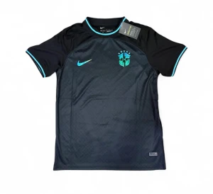 Svart Brasilien Nike fotbollströja - Snygg svart fotbollströja från Nike med Brasilien-emblem på bröstet och turkosa detaljer vid ärmslut och krage. Tröjan har korta ärmar och är tillverkad i ett lätt och ventilerande material, perfekt för träning eller match.