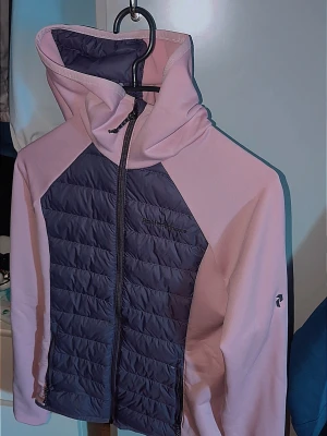 Ljusrosa och mörkblå jacka med huva - Snygg jacka i ljusrosa med mörkblå quiltad front och huva. Jackan har dragkedja hela vägen, två fickor och sportig look. Perfekt för lager-på-lager och chill vardagsstil. Helt ny dam jacka köpt för 1100 använd 1 gång HELT NY bara testats 