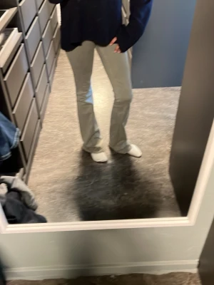 Ljusgrå bootcut jeans - Säljer ett par ljusgröna bootcut jeans med lågmidja och klassisk femficksdesign. Jeansen har en snygg, figurnära passform upptill och släpper ut nedtill för en trendig siluett. Perfekta för dig som vill ha en clean och stilren look.
