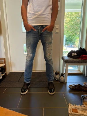 Slim fit ljusblå dondup jeans  - Säljer ett par slim fit ljusblå dondup jeans med slitningar och tvättade detaljer. Jeansen har klassisk femficksmodell och smal passform som sitter snyggt längs benen. Perfekta för en avslappnad och trendig look. 