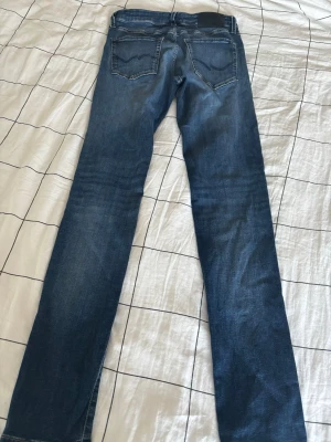 Blå raka jeans från Jack & Jones - Säljer ett par klassiska blå jeans från Jack & Jones med raka ben och femficksmodell. Jeansen har en snygg tvätt och kontrastsömmar. Perfekta till en avslappnad stil och passar till det mesta. Materialet är mjukt denim för skön känsla.