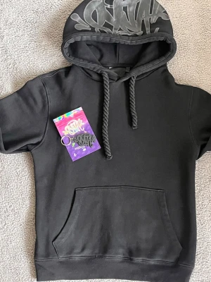 SYNAWORLD HOODIE  - SYNAWORLD HOODIE ✅ STORLEK XS ✅ 80% BOMULL 20% POLYESTER ✅ FAST DET KÄNNS SOM ATT DEN ÄR 100% BOMULL JÄTTE SKÖNT OCH TJOCK MATERIAL ✅ DU FÅR ÄVEN MED DEN LILLA PÅSEN SOM INNEHÅLLER EN NYCKELHÅLLARE VILKET SER RIKTIGT SNYGGT UT MED DEN SVARTA HOODIEN PERFEKT HÖSTEN 🍂 OCH VINTER OCH INGA DEFEKTER MED ✅