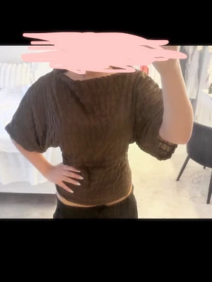 Brun topp från Nelly med struktur - Säljer en brun topp från Nelly i storlek S. Toppen har en strukturerad yta, lös passform och korta ärmar. 