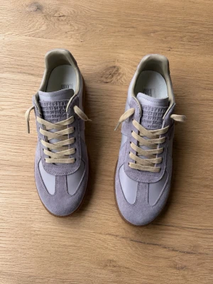 Maison Margiela Gats Purple Tint - Hej! Jag säljer ett par Maison Margiela GATs i fint skick, storlek 43. Mitt lila par. Köptes ett tag sedan och har knappt  använts.  Endast skor och dustbag medföljer, box är tyvärr borta. Säljer av lite plagg från garderoben nu. Skriv om ni har några som helst frågor. Säljer för 2250kr.