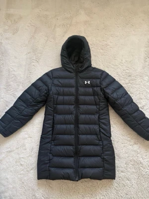 Under Armour jacka  - Svart lång dunjacka från Under Armour. Den har ett litet hål vid sidan men det syns inte om man inte vet om det. Pris kan diskuteras vid snabbt köp. Nypris 2500kr.