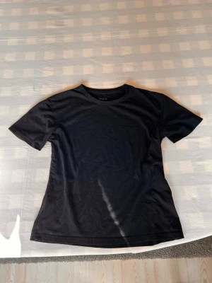 Svart basic t-shirt - En enkel svart t-shirt med rund hals och korta ärmar. Perfekt till jeans eller shorts och funkar året runt. Tillverkad i mjukt material som känns skönt mot huden.