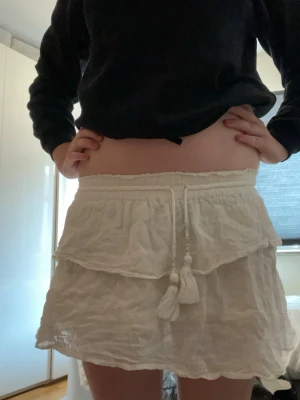 Vit volangkjol från Gina Tricot - Söt vit kjol från Gina Tricot med volangkant och resår i midjan. Den är lite missfärgad på insidan av solkräm som man ser på bild 2 därav priset men det syns inte då det är på insidan den är i storlek 146/152/xs. Pris kan diskuteras och skriv för mer bilder