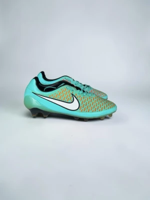 Magista  - Storlek: 45.5  Säljer dessa i den fräscha turkosa/mintgröna färgställningen med korallröda accenter i mönstret på ovanlägget. Klassisk vit Nike-swoosh mot mörk mellansula med skruvdubbar (SG) för mjukare underlag. Dynamic Fit-kragen ger sockliknande passform runt ankeln för extra stöd i varje rörelse.