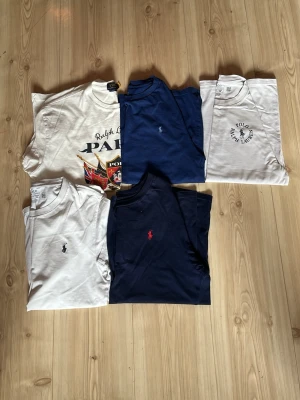 Mörkblå t-shirt från Polo Ralph Lauren - Snygg mörkblå t-shirt från Polo Ralph Lauren med klassisk röd broderad logga på bröstet. T-shirten har rund halsringning och korta ärmar. Tillverkad i mjuk bomull för en skön känsla. (En för 400kr)