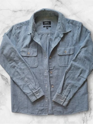 Randig Skjorta från A.P.C - Säljer denna sjukt snygga skjortan i en härlig blåvit färg. Fina detaljer med silverknappar. Storlek 36 ≈ S/XS Pris kan diskuteras 🤩
