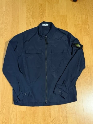 Stone Island jacka  - Säljer denna Stone Island overshirt/vindjacka den är i väldigt bra skick använd en gång den är i storlek m men sitter mkt mer som s. Hör gärna av er vid funderingar🤝
