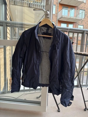 Kashmir windbreaker massimo dutti - Snygg mörkblå windbreaker från Massimo Dutti med kashmir på insidan och tryckknappar framtill. Jackan har två fickor och justerbara ärmslut. Lätt och smidig modell, perfekt för blåsiga dagar.