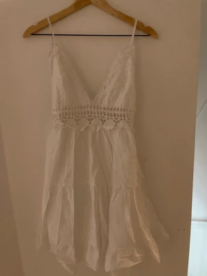 Vit kort klänning med spets och knyt -  Köpt i gatubutik i Italien så har inget varumärke.❣️