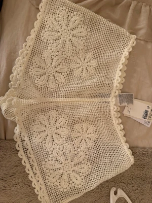 Vita virkade shorts med blommönster - Superfina virkade shorts i vitt med blommiga detaljer och vågig kant. Perfekta för sommaren till stranden. Ifrån hm och är helt oanvänd med prislapp