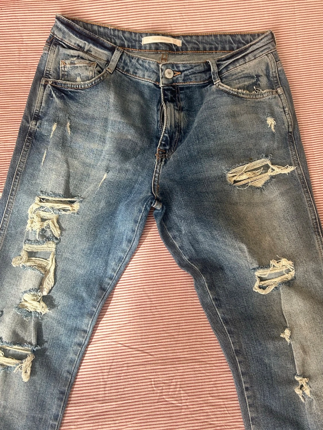 Blå slitna jeans med hål