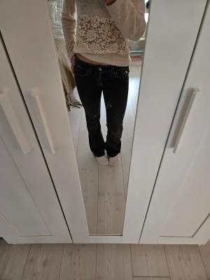 Bootcut jeans - Säljer ett par svarta bootcut jeans med vita kontrastsömmar och låg midja. Jeansen har klassisk femficksdesign och är low waist. Säljer p.g.a för små, knappt använda