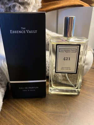 The Essence Vault 421 Inspired by Santal 33 - The Essence Vault 421 Eau de Parfum (100 ml). Doften är elegant och exklusiv, inspirerad av den välkända klassikern Le Labo Santal 33. Parfymen är sparsamt använd endast ett fåtal gånger (se bilder) och har förvarats mörkt och svalt.