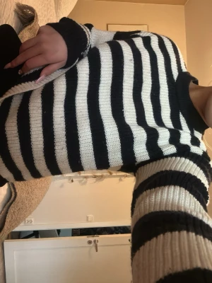 Randig stickad tröja i svart och vitt - Säljer en snygg stickad tröja med breda svarta och vita ränder från Monki 