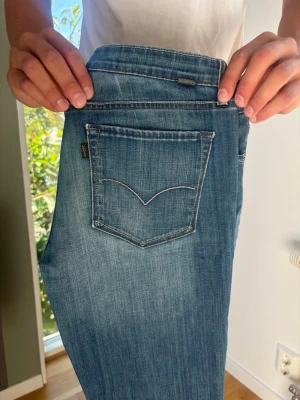 Rare Black Tab Levi's bootcut jeans blå W29 L32 - RARE Levi's Black Tab jeans med riktigt snygga detaljer. Från Always Honestly Made kollektionen. Väldigt unika jeans! Unisex Färg: Blå Passform: Bootcut Storlek: W29 L32 Skick: B Grade Mått [platt] (±1 cm): A: 39 cm B: 103 cm C: 26 cm D: 21 cm Tveka inte att höra av dig vid frågor eller funderingar.  Skickas snabbt!