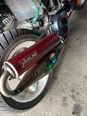Yasuni Z - Säljer ett trimavgassystem från Yasuni till scooter. Utrustad med röd ljuddämpare och metallrör med snygg svetsning och färgskiftningar. Passar perfekt för dig som vill ha bättre prestanda och coolare look på mopeden.