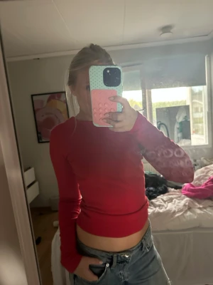 Röd långärmad croppad topp - Snygg röd långärmad topp med croppad passform. Enkel och stilren design utan synliga mönster eller detaljer, perfekt att matcha med jeans eller kjol. Mjuk och stretchig känsla, passar dig som gillar en tight och bekväm look. från stradivarius i storlek s❤️