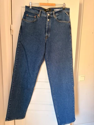 Blå raka jeans replay - Blå Replay jeans med rak passform. Storlek - W32 L34. Modellen är M9Z1. Jeansen har fem fickor och knappgylf. Tillverkade i slitstark denim som ger en tidlös look.