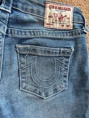 True religion jeans  - Skitsnygga jeans från true religion lågmidjade och bootcut. Storlek 25 Dom är jättebra skick förutom längst ner där sömmen har gått upp  men det syns knappt när man har dom på och annars kan jag tycka att det bara är snyggt. Nypris: 1399kr Skriv om du har nån fråga eller vill ha fler bilder 💕💕