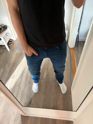 Blå slim fit jeans herr från replay - Säljer ett par klassiska blå slim fit jeans med normal midja och smal passform. Jeansen har fem fickor och stängs med dragkedja och knapp. Perfekta till en avslappnad stil och passar till det mesta. Materialet är mjukt och stretchigt för extra komfort.
