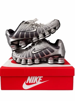 Nike Shox TL silver sneakers - Nike Shox TL sneakers i metallic silver med svart swoosh och unika fjädrande sulor. Ovandelen är i mesh och syntetmaterial med futuristisk design och svarta detaljer. Skorna har lågt skaft och klassisk snörning. Perfekta för dig som gillar statement sneakers.
