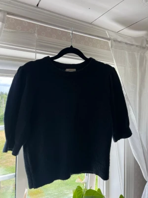 Blå stickad tröja med puffärm  - Säljer en blå stickad tröja med rund halsringning och trendiga puffärmar. Tröjan har en rak passform och är tillverkad i ett mjukt stickat material. 